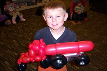 boy holding balloon animal truck